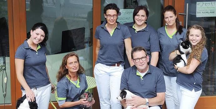 The veterinary team standing outside the Kamlage practice in Odenthal, holding dogs and a cat.