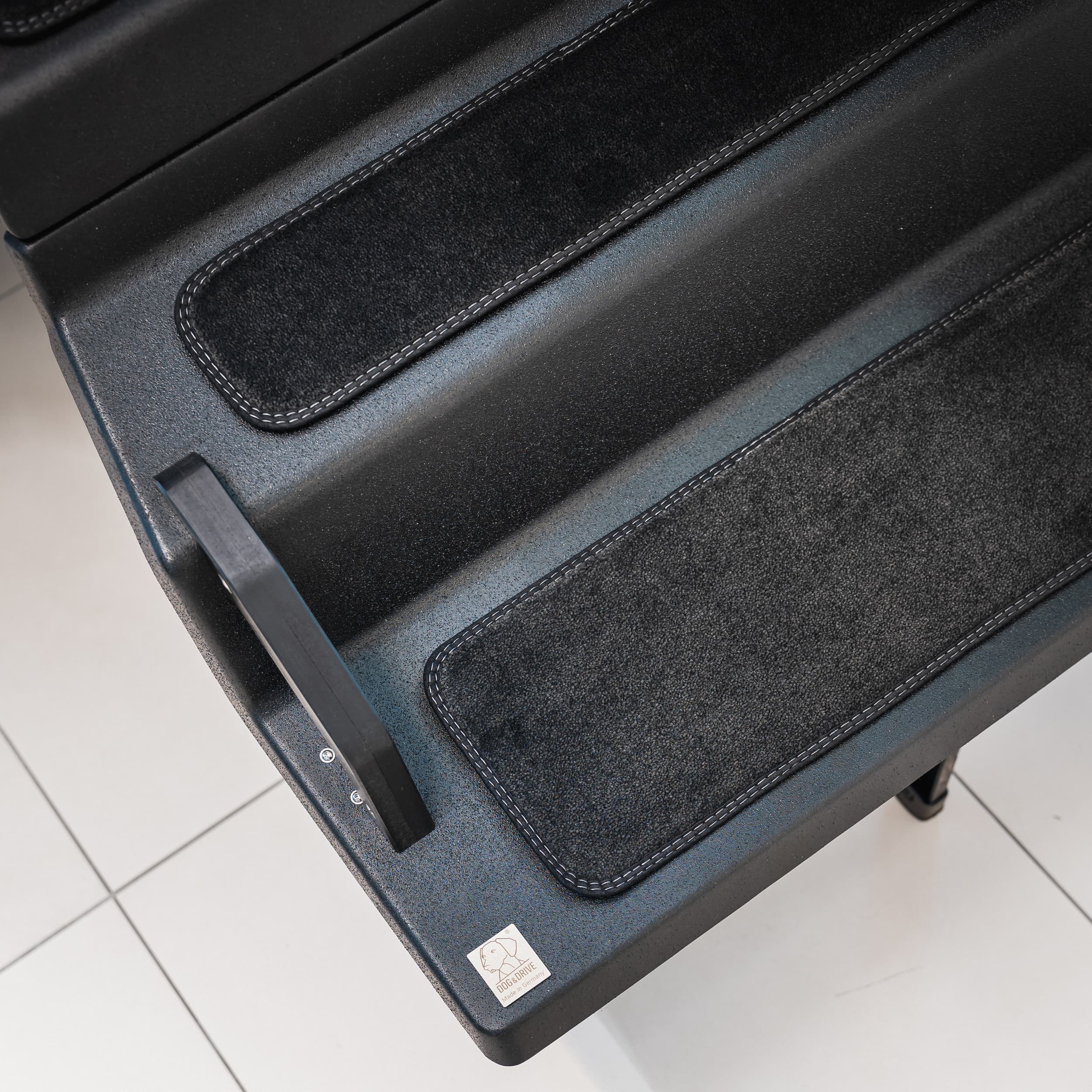 The rubberised anti-slip step surface beside a fitted anti-slip mat
